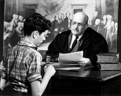 Juez sentado en su escritorio hablando con un niño de Unknown